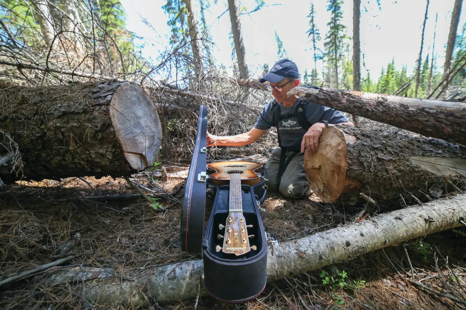 Rick Bass opening Black Ram guitar case in forest