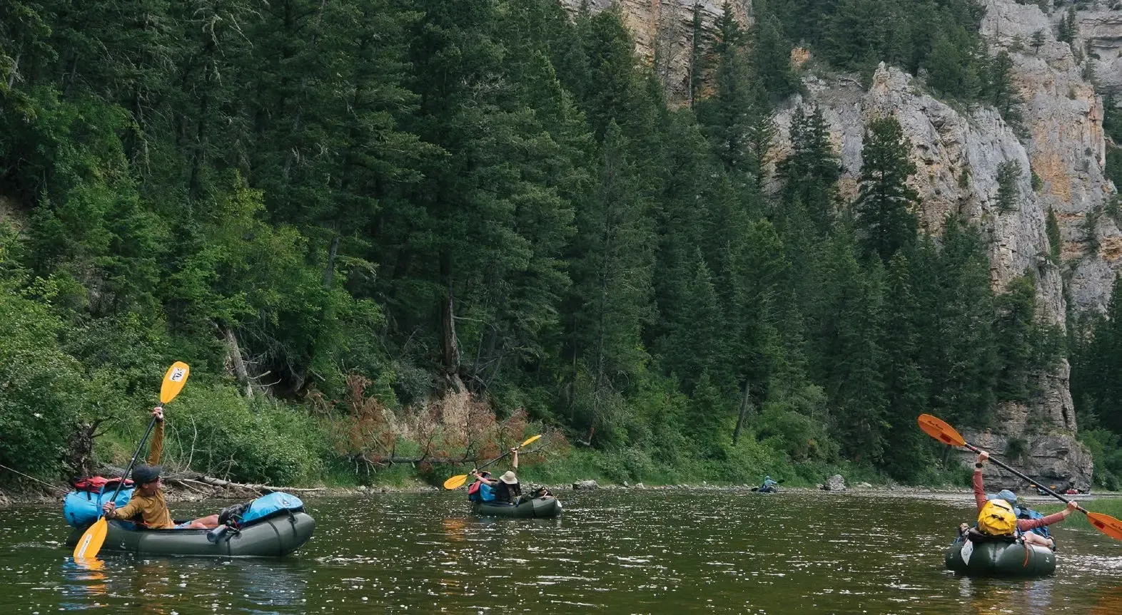 Floating Through Old Water Conflicts 3 Pack-rafters on the Smith River stretch their arms wide toward the sky