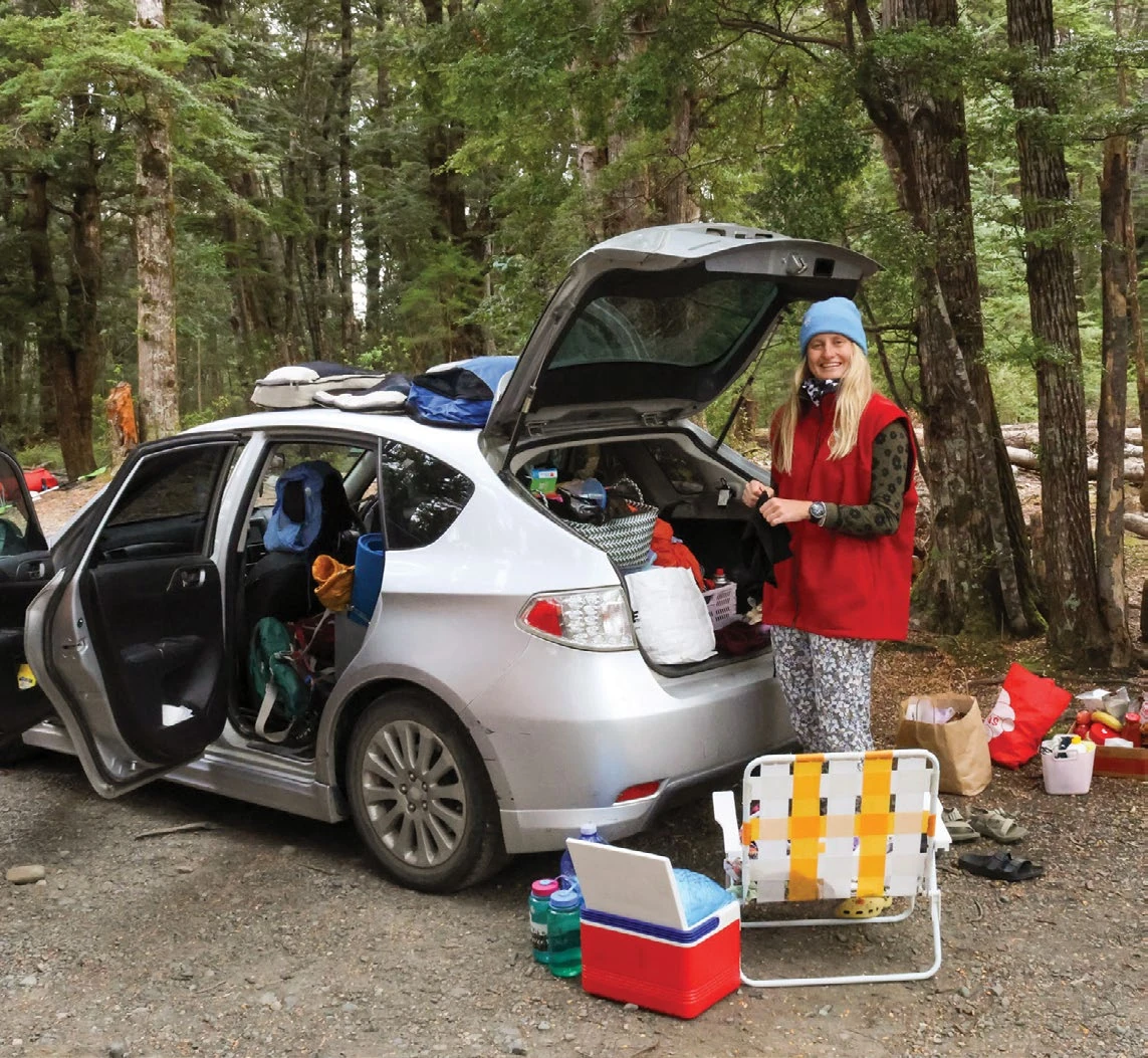 A small silver hatchback packed with camping gear