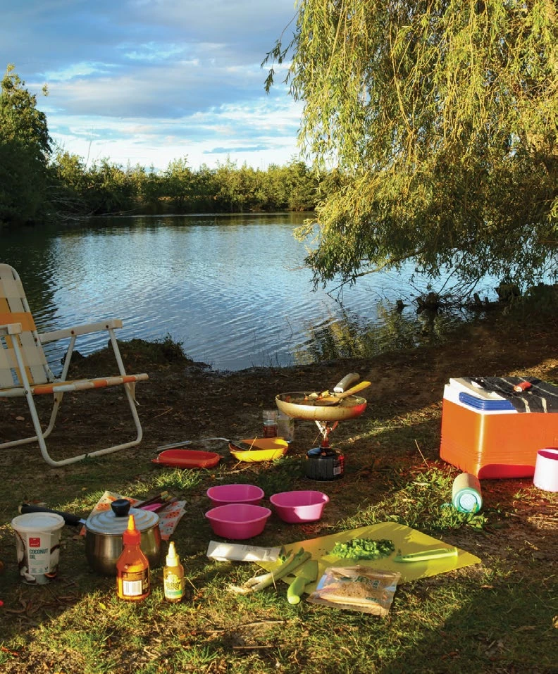 Evening light on a lakeside camp kitchen as dinner is prepared